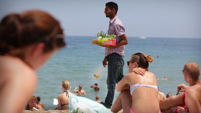 The Mojiteros concoct their drinks - with various fruits and additives - and hide them away from view of the Policia