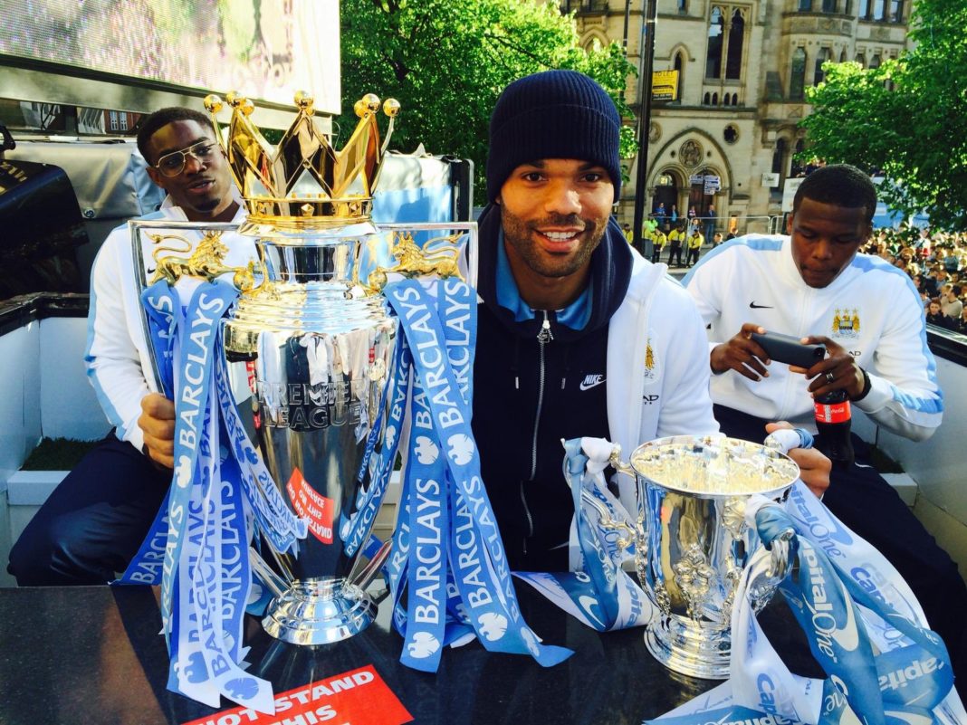 Lescott in his Man City days with the Premier League trophy