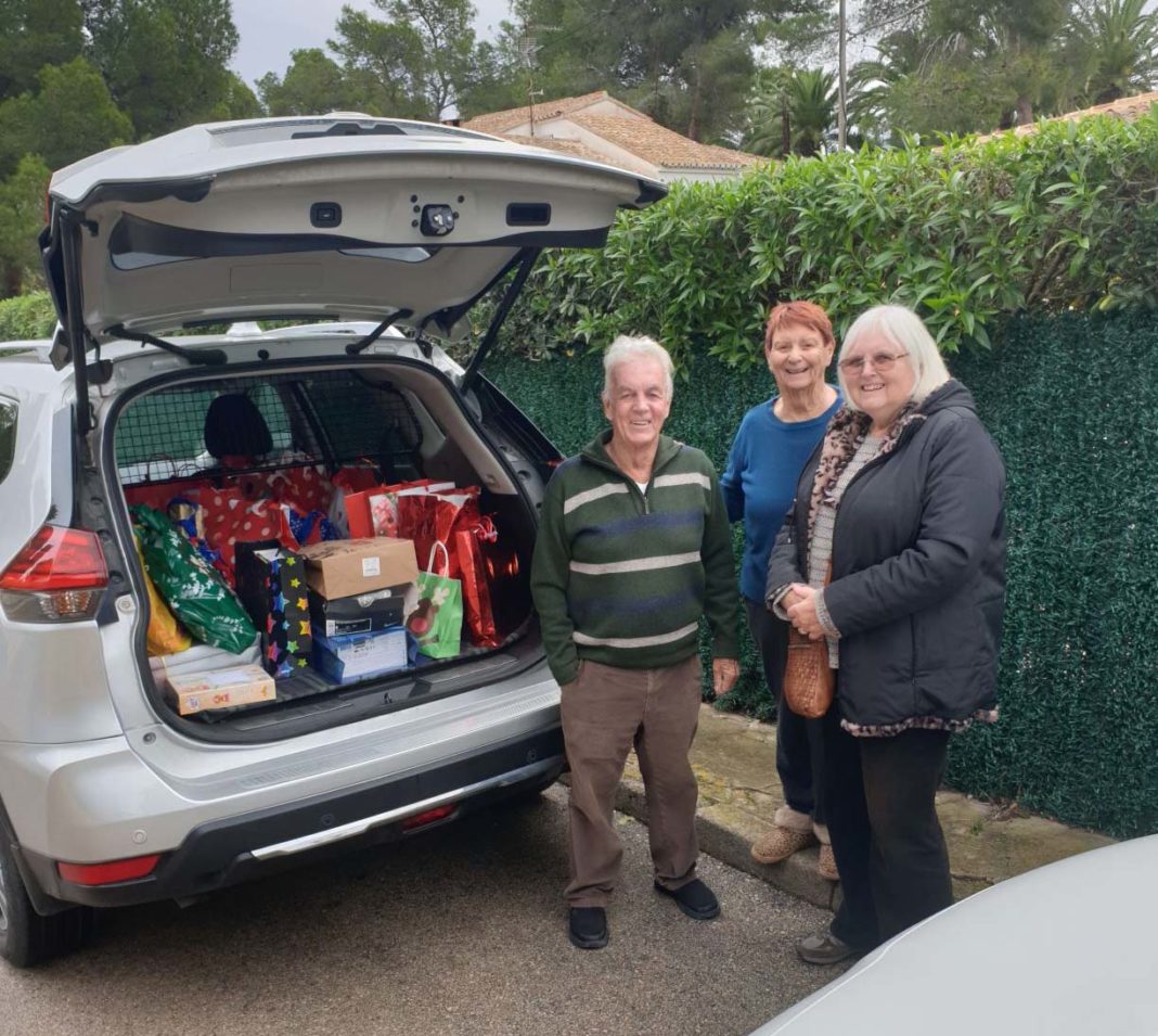 Local Freemasons help the  Red Cross distribute presents to needy children.