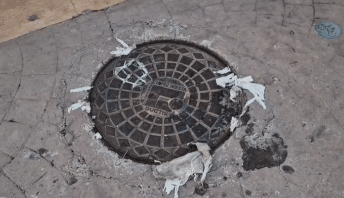 The manhole cover was displaced by the upward pressure of the sewerage which flooded much of the promenade