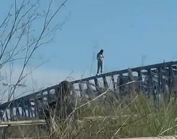 A tense scene unfolded today as a young woman climbed to the top of the iron bridge over the AP-7 near Lomas de Cabo Roig.