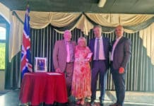 Maria Wilson de rosa mientras finalmente consigue su BEM Maria Wilson con su esposo y su hijo mientras recibe su BEM del embajador británico Sir Alex Ellis