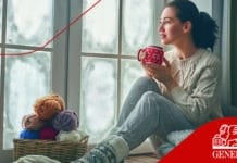 Keep your Spanish home comfortable and protected with Generali Expatriates Beautiful young woman sitting by the window and looking at frozen glass. Girl enjoying warm beverage.